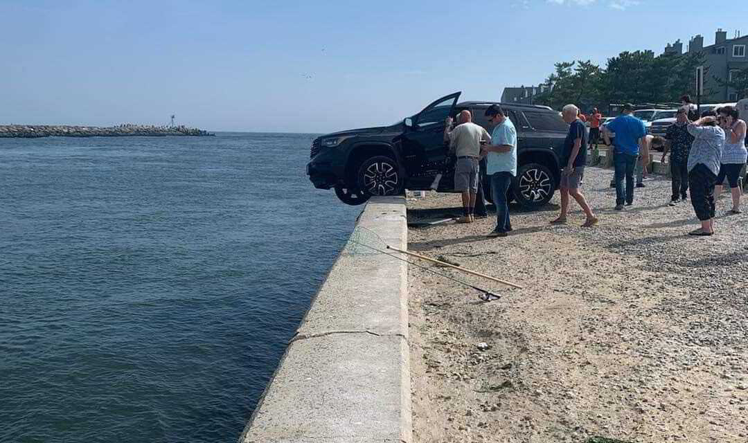 CAR DRIVES OFF PARKING LOT ON WALL OF MANASQUAN INLET